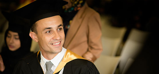 University of Bradford graduate wearing mortarboard hat and gown