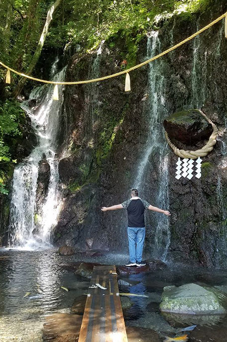 University of Bradford student Xander standing in front of a waterfall in Hakone Japan