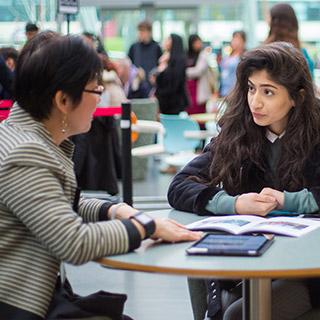 2 professionals talking in the Atrium at the University of Bradford