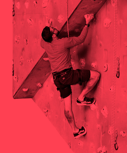 Man climbing on a roped climbing wall. 